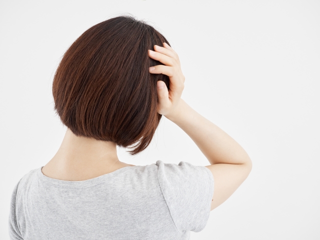 頭痛がする後ろ姿の女性